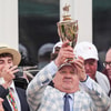 Trainer Kenny McPeek holds the Gold Cup with wife Sherri with daughter Ann wearing a 150th Kentucky Derby hat below him in the Winner's Circle after Mystik Dan won the 2024 Kentucky Derby at Churchill Downs Saturday, May 4, 2024 in Louisville, Kentucky. (© Matt Stone/The Courier Journal / USA TODAY NETWORK)