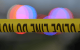 Police tape is strung up with police sirens flashing in the background - © John Oliva/Caller-Times / USA TODAY NETWORK