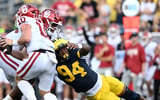 Sep 12, 2026; Ann Arbor, Michigan, USA; Oklahoma Sooners quarterback John Mateer (10) scrambles with the ball under pressure from Michigan Wolverines defensive end Nate Marshall (94) during the fourth quarter at Michigan Stadium. Mandatory Credit: Lon Horwedel-Imagn Images