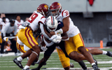 Wide receiver Anthony Simpson #1 of the Arizona Wildcats is tackled by defensive lineman Tyrone Taleni #31 and defensive back Jaylin Smith #19 of the USC Trojans during the first half of the game at Arizona Stadium on October 29, 2022 in Tucson, Arizona.
