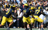 Michigan Wolverines football quarterback Bryce Underwood handing off to Jordan Marshall with Blake Frazier blocking. (Photo by Lon Horwedel / TheWolverine.com)