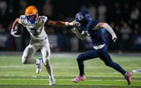 Battle Ground's Maddox Porter (3) holds out his arm against Grace's Campbell Johnson (7) during a TSSAA high school football