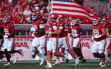 Sep 26, 2026; Fayetteville, Arkansas, USA;  Arkansas Razorbacks run onto the field with the American flag prior to the game against the Tulsa Golden Hurricanes at Donald W. Reynolds Razorback Stadium.  Mandatory Credit: Nelson Chenault-Imagn Images