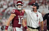 Oklahoma Sooners quarterback John Mateer (10) and coach Brent Venables talk after a play during a college football game between