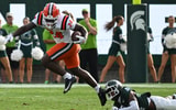 Oct 10, 2026; East Lansing, Michigan, USA;  Illinois Fighting Illini running back Javari Barnett (24) runs through a Michigan State Spartans defensive back Charles Brantley (4) tackles during the first quarter at Spartan Stadium.  Credit: Dale Young-Imagn Images