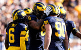 Michigan defensive end Dom Nichols (8), left, and defensive end John Henry Daley (90) celebrates a play against Iowa during the