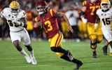 Quarterback Caleb Williams #13 of the USC Trojans rushes out of the pocket and gains a first down ahead of B.J. Green II #35 of the Arizona State Sun Devils during the second half at United Airlines Field at the Los Angeles Memorial Coliseum on October 1,
