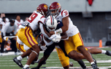 Wide receiver Anthony Simpson #1 of the Arizona Wildcats is tackled by defensive lineman Tyrone Taleni #31 and defensive back Jaylin Smith #19 of the USC Trojans during the first half of the game at Arizona Stadium on October 29, 2022 in Tucson, Arizona. 