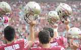 FSU football players hold up their helmets in pregame