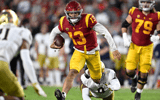 Quarterback Caleb Williams #13 of the USC Trojans scrambles for a first down against defensive lineman Justin Ademilola #9 of the Notre Dame Fighting Irish in the first half of a NCAA football game at the Los Angeles Memorial Coliseum in Los Angeles on Sa