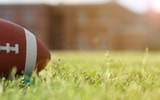 American football on stadium field at school campus.