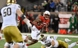 Oct 7, 2023; Louisville, Kentucky, USA; Louisville Cardinals defensive back Devin Neal (27) returns an interception past Notre Dame Fighting Irish tight end Mitchell Evans (88) during the second half at L&N Federal Credit Union Stadium. Louisville defeated Notre Dame 33-20. Mandatory Credit: Jamie Rhodes-Imagn Images