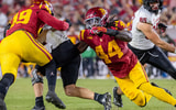 USC defensive ends Kameryn Fountain and Sam Greene combine on a tackle for the Trojans during a game against the Rutgers Scarlet Knights