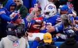 Ray Davis (22) jumps into the stands to celebrate scoring a touchdown against the Miami Dolphins - Gregory Fisher, Imagn Images