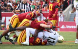 USC defenders finish off a tackle of Notre Dame quarterback Riley Leonard during a game between the Trojans and Fighting Irish