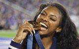 Former Kentucky track star Masai Russell bites her Olympic gold medal at the Georgia game - Dr. Michael Huang, Kentucky Sports Radio