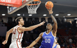 Feb 26, 2025; Norman, Oklahoma, USA; Kentucky Wildcats guard Otega Oweh (00) goes up for a shot as Oklahoma Sooners forward Sam Godwin (10) defends during the first half at Lloyd Noble Center. Mandatory Credit: Alonzo Adams-Imagn Images