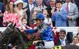Kelly Alvarado captures the moment as her husband, jockey Junior Alvarado, tosses roses into the air in the Winner's Circle as their children celebrate behind him after he and Sovereignty won the 2025 Kentucky Derby Saturday, May 3, 2025 at Churchill Downs in Louisville, Kentucky.