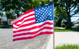 An American flag for Memorial Day waves at the end of a driveway along Quill Road in Levittown on May 20, 2025. © Daniella Heminghaus | Bucks County Courier Times / USA TODAY NETWORK via Imagn Images