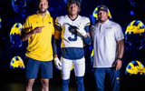 DB Andrew Clark with Michigan coaches Lamar Morgan and Lionel Stokes.