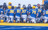The Barrow Whalers huddles before an Alaska high school football game.