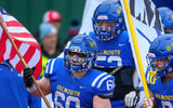 The Falmouth Navigators football team enter the field before a Maine high school football game.