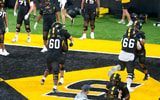 Johnny Williams (60) and Logan Reichert (66) go through warm up blocking drills