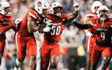 Louisville Cardinals defensive lineman Clev Lubin (50) and teammates Louisville Cardinals defensive back Tayon Holloway (25), left, and Louisville Cardinals defensive lineman Wesley Bailey (23) and Louisville Cardinals linebacker Antonio Watts (9) celebrate creating a turnover on James Madison University as the Cards' beat the visiting Dukes 28-14 Friday September 5, 2025 at L&N Credit Union Stadium in Louisville, Kentucky.