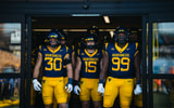West Virginia's players take the field against Pitt