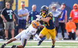 West Virginia Mountaineers running back Clay Ash breaks the tackle against Pitt