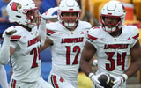 Sep 27, 2025; Pittsburgh, Pennsylvania, USA; Louisville Cardinals defensive back Corey Gordon (24) and linebacker Kalib Perry (12) celebrate an interception by linebacker TJ Quinn (34) against the Pittsburgh Panthers during the fourth quarter at Acrisure Stadium. Mandatory Credit: Charles LeClaire-Imagn Images