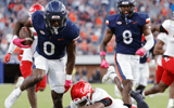 Oct 12, 2024; Charlottesville, Virginia, USA; Virginia Cavaliers running back Xavier Brown (0) carries the ball to score a touchdown against the Louisville Cardinals during the second half at Scott Stadium. Mandatory Credit: Amber Searls-Imagn Images