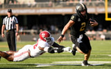Oct 5, 2024; Nashville, Tennessee, USA; Vanderbilt Commodores quarterback Diego Pavia (2) breaks the tackle of Alabama Crimson Tide defensive lineman LT Overton (22) during the first half at FirstBank Stadium. Mandatory Credit: Steve Roberts-Imagn Images