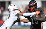 Oct 19, 2024; Louisville, Kentucky, USA; Louisville Cardinals running back Isaac Brown (25) runs the ball against Miami Hurricanes defensive back D'Yoni Hill (19) during the first half at L&N Federal Credit Union Stadium. Mandatory Credit: Jamie Rhodes-Imagn Images