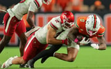 Oct 17, 2025; Miami Gardens, Florida, USA; Miami Hurricanes wide receiver Keelan Marion (0) carries the football against Louisville Cardinals linebacker Kalib Perry (12) during the third quarter at Hard Rock Stadium. Mandatory Credit: Sam Navarro-Imagn Images