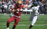 Oct 18, 2025; Chestnut Hill, Massachusetts, USA; Boston College Eagles quarterback Grayson James (3) stiff arms UConn Huskies linebacker Aaron Key (5) during the first half at Alumni Stadium. Mandatory Credit: Bob DeChiara-Imagn Images