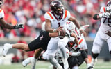 Louisville Cardinals defensive lineman Mason Reiger (95) gets an arm around Virginia Tech Hokies quarterback Kyron Drones (1) as the Cards rolled past Virginia Tech 34-3 Saturday. Nov.4, 2023.