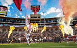 The Texas Tech Red Raiders run out of the tunnel in a packed Jones stadium during homecoming