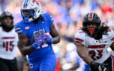 Nov 22, 2025; Dallas, Texas, USA; SMU Mustangs running back T.J. Harden (27) eludes the tackle of Louisville Cardinals defensive lineman Wesley Bailey (23) for a touchdown during the first half at Gerald J. Ford Stadium. Mandatory Credit: Jerome Miron-Imagn Images