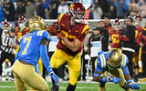 USC Trojans tight end Lake McRee (87) runs a pass between UCLA Bruins defensive back K.J. Wallace (7) and defensive back Bryan Addison (4) during the second quarter at Rose Bowl