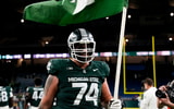Michigan State offensive lineman Gavin Broscious (74) carries a Michigan State flag after defeating Maryland at Ford Field. - Brendan Mullin, USA TODAY Sports