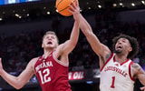 Indiana Hoosiers forward Tucker DeVries (12) and Louisville Cardinals guard J'Vonne Hadley (1) battle for control of the ball during a game Saturday, Dec. 6, 2025, at Gainbridge Fieldhouse in Indianapolis. Louisville defeated Indiana 87-78.