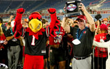 Dec 23, 2025; Boca Raton, FL, USA; Louisville Cardinals head coach Jeff Brohm raises the trophy after defeating the Toledo Rockets in the Boca Raton Bowl at Flagler CU Stadium. Mandatory Credit: Jeff Romance-Imagn Images