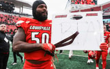 Louisville Cardinals defensive lineman Clev Lubin (50) held a coach's whiteboard with the letters BTA and carried a belt after the Cards dominated rival Kentucky 41-0 Saturday, November 29, 2025 in Louisville, Kentucky.