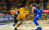 West Virginia guard Jasper Floyd drives against Kansas