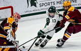 Michigan State's Tiernan Shoudy, center, almost gets the puck past Minnesota's Liam Souliere, left, as Minnesota Jimmy Snuggerud, right, closes in during overtime on Saturday, Jan. 25, 2025. - Nick King, USA TODAY Sports