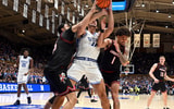 Jan 26, 2026; Durham, North Carolina, USA; Duke Blue Devils forward Cameron Boozer (12) grabs a rebound in between Louisville Cardinals center Aly Khalifa (15) and guard J'Vonne Hadley (1) during the second half at Cameron Indoor Stadium. Mandatory Credit: Rob Kinnan-Imagn Images