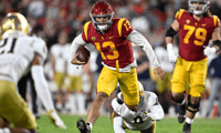 Quarterback Caleb Williams #13 of the USC Trojans scrambles for a first down against defensive lineman Justin Ademilola #9 of the Notre Dame Fighting Irish in the first half of a NCAA football game at the Los Angeles Memorial Coliseum in Los Angeles on Sa