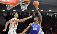 Feb 26, 2025; Norman, Oklahoma, USA; Kentucky Wildcats guard Otega Oweh (00) goes up for a shot as Oklahoma Sooners forward Sam Godwin (10) defends during the first half at Lloyd Noble Center. Mandatory Credit: Alonzo Adams-Imagn Images