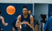 West Virginia guard Chance Moore bringing in the pass at practice